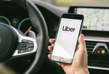 Imagem de um celular mostrando o logo da Uber dentro de um carro, destacando a interface do aplicativo.