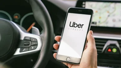 Imagem de um celular mostrando o logo da Uber dentro de um carro, destacando a interface do aplicativo.