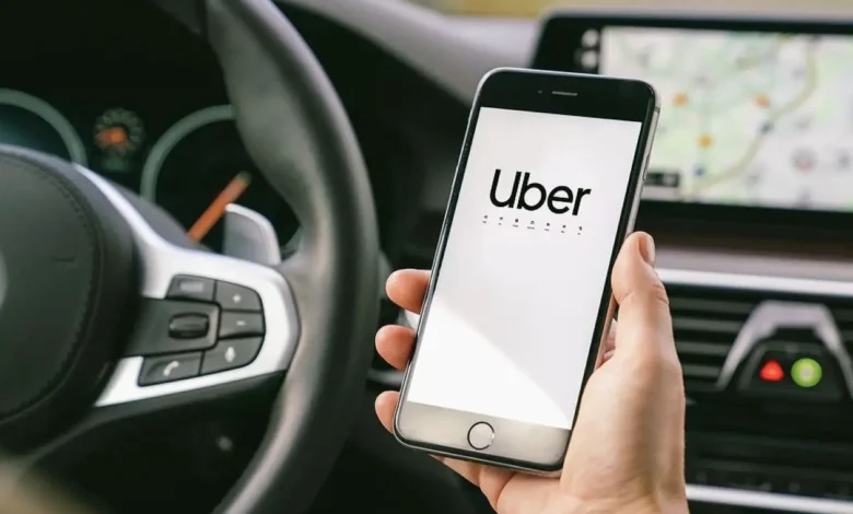 Imagem de um celular mostrando o logo da Uber dentro de um carro, destacando a interface do aplicativo.