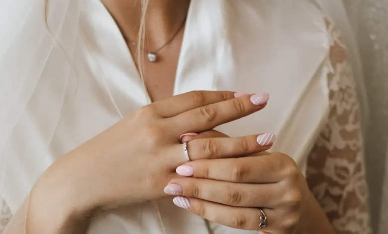 Unhas decoradas para casamento: noiva colocando anel de noivado.