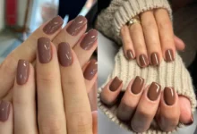 Unhas curtas esmaltadas em tons de marrom com acabamento brilhante.