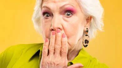 Mulher idosa estilosa com unhas decoradas e expressão surpresa