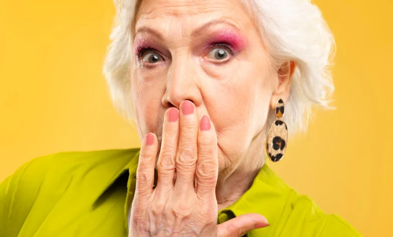Mulher idosa estilosa com unhas decoradas e expressão surpresa