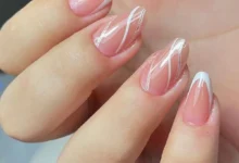 Unhas amendoadas com detalhes brancos, oferecendo um visual moderno e elegante.