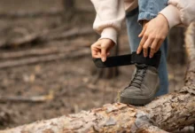 Pessoa ajustando o velcro de um tênis em um cenário natural, como uma solução para tênis com velcro desgastado.