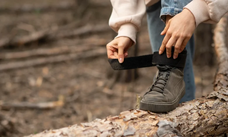 Pessoa ajustando o velcro de um tênis em um cenário natural, como uma solução para tênis com velcro desgastado.