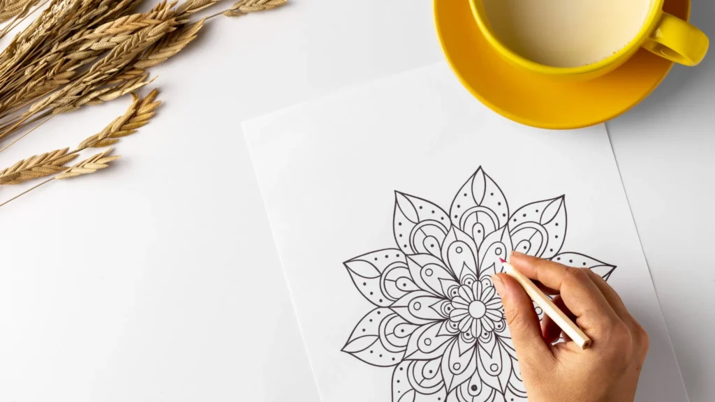 Imagem superior de uma mandala sendo colorida com lápis de cor.