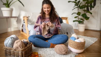 Mulher feliz tricotando em casa, destacando a tendência do crochê que está ganhando popularidade globalmente.