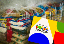 Cartão do Bolsa Família em frente a sacos de cestas básicas, simbolizando o auxílio governamental.