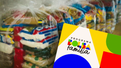 Cartão do Bolsa Família em frente a sacos de cestas básicas, simbolizando o auxílio governamental.