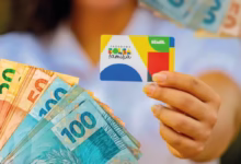 Cartão do Bolsa Família com cédulas de dinheiro, representando o pagamento do benefício em agosto de 2025."