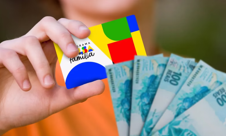 Cartão do Bolsa Família e notas de R$100, representando o benefício financeiro disponível para saque.