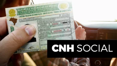 Imagem de uma carteira de habilitação brasileira sendo segurada, com uma mão em destaque, enquanto o motorista está no banco do passageiro de um carro. O tema é sobre a CNH Social 2025.