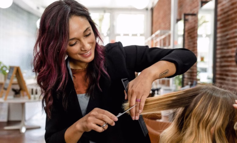 Cabeleireira fazendo corte em V em cabelo loiro com luzes