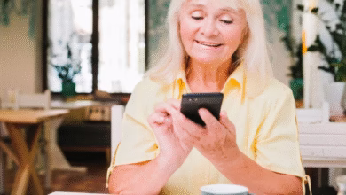 Mulher sorridente enviando mensagem de bom dia pelo celular