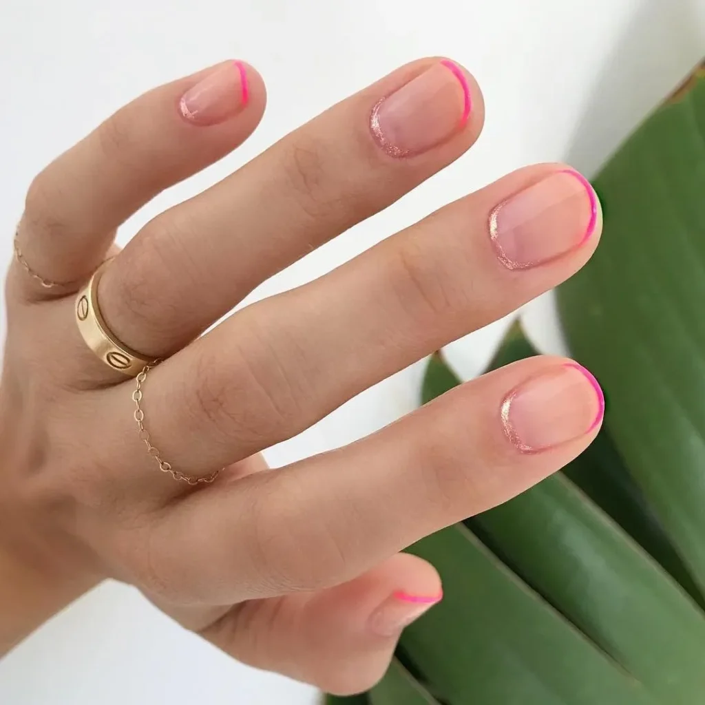 Unhas com francesinha invertida, acabamento em neon pink e um toque de brilho nas pontas