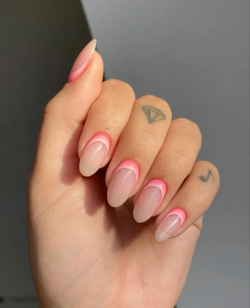 Unhas com francesinha invertida, adornadas com listras finas em rosa