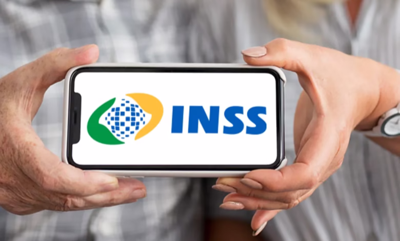 Logo do INSS exibido em um celular, simbolizando o serviço de pagamento de benefícios