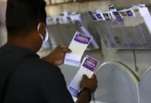 Loteria da Lotofácil da Independência 2025 sendo apostada por um homem, com bilhetes visíveis de diferentes jogos ao fundo.