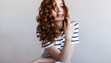 Mulher ruiva com cabelo ondulado e volumoso, representando uma mudança de visual.