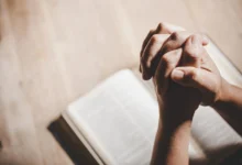 Mãos unidas em oração sobre uma Bíblia Sagrada, refletindo gratidão a Deus por mais um dia.