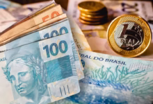 Notas de dinheiro e moedas do real, representando o tema do bloqueio de instituições financeiras para empréstimo consignado INSS.