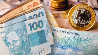 Notas de dinheiro e moedas do real, representando o tema do bloqueio de instituições financeiras para empréstimo consignado INSS.