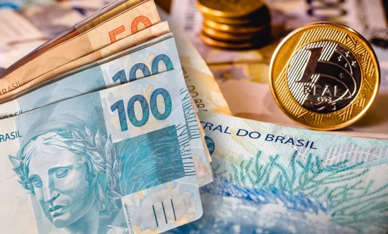 Notas de dinheiro e moedas do real, representando o tema do bloqueio de instituições financeiras para empréstimo consignado INSS.