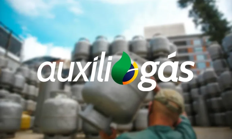 Homem carrega botijão de gás próximo a pilha de cilindros, com o logo do Auxílio Gás em destaque.