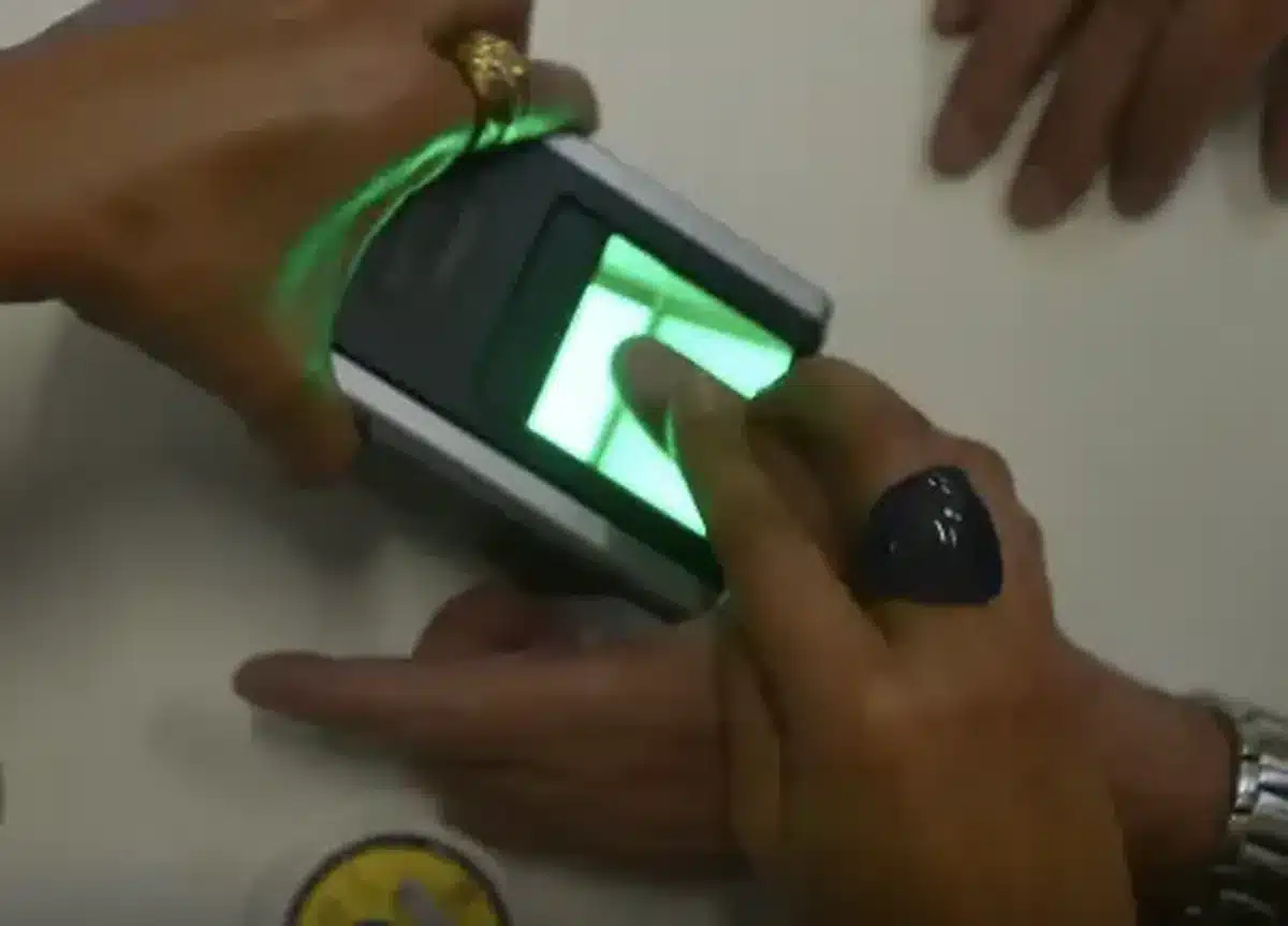 Pessoa realizando coleta de biometria digital em equipamento no INSS