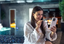 Mulher sorridente enviando mensagem de boa noite pelo celular