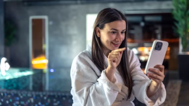Mulher sorridente enviando mensagem de boa noite pelo celular