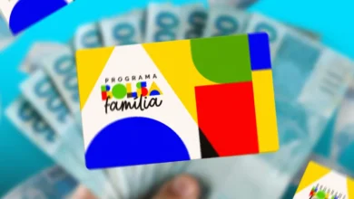 Cartão do Bolsa Família sobre notas de dinheiro, com destaque para o logotipo colorido do programa e o fundo azul.
