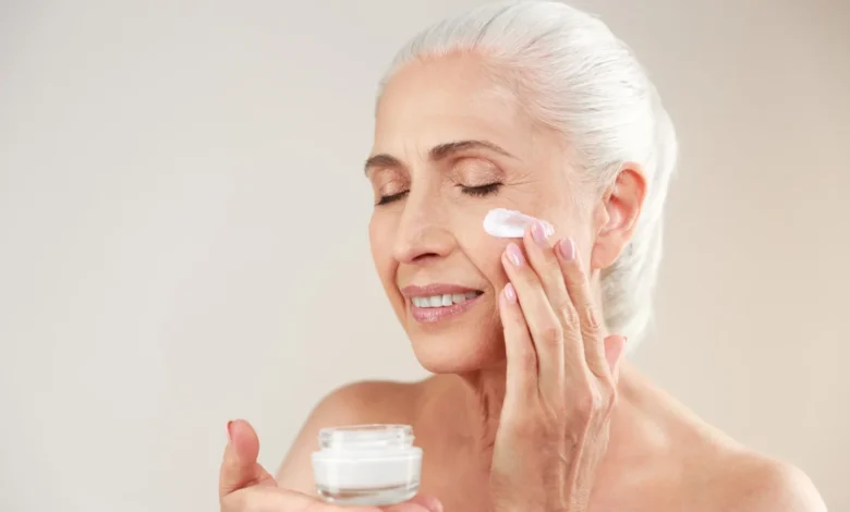 Mulher idosa aplicando creme facial para cuidados com a pele