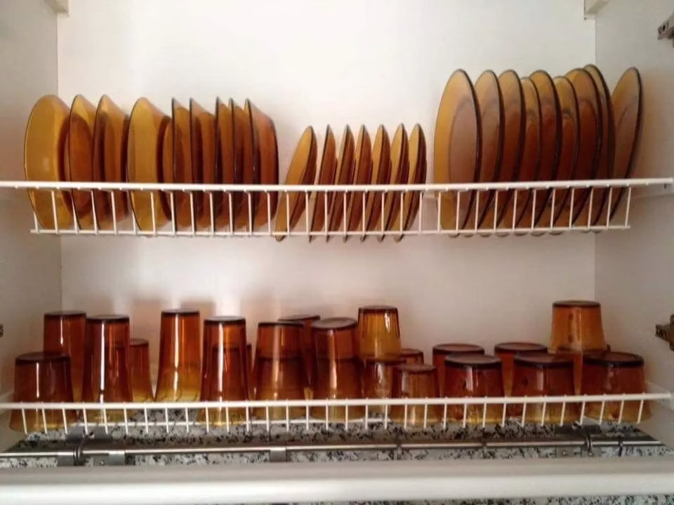 Prateleira com copos e pratos Duralex âmbar, itens de coleção que podem valer um bom dinheiro.