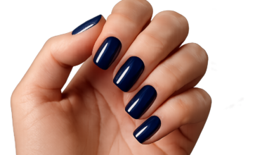 Mão com unhas pintadas de esmalte azul profundo, destacando a cor ousada e elegante.