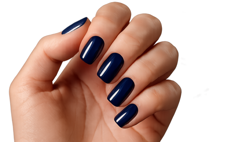 Mão com unhas pintadas de esmalte azul profundo, destacando a cor ousada e elegante.