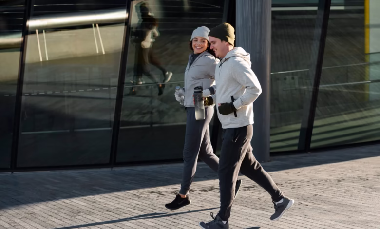 Casal se exercitando juntos ao ar livre no inverno, mantendo uma rotina ativa mesmo com o frio.