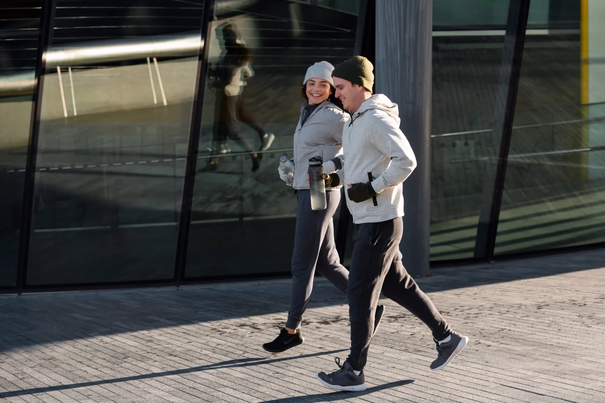 Casal se exercitando juntos ao ar livre no inverno, mantendo uma rotina ativa mesmo com o frio.