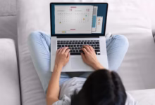 Mulher jovem em seu laptop em casa vendo datas para planejar o feriado prolongado de novembro.