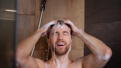 Homem tomando banho quente e lavando o cabelo com shampoo