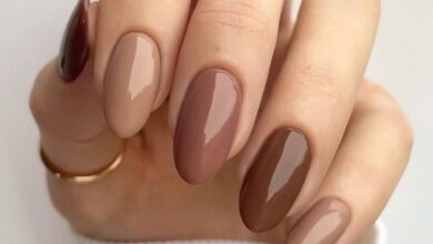 Unhas de manicure sofisticada em tons de marrom, com acabamento brilhante e minimalista.