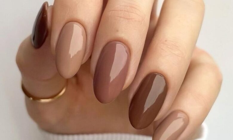 Unhas de manicure sofisticada em tons de marrom, com acabamento brilhante e minimalista.