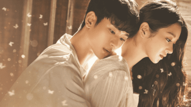 Cena emocionante de Tudo Bem Não Ser Normal, com Moon Gang-tae e Ko Moon-young, onde ele a abraça de forma protetora. A imagem é iluminada com borboletas esvoaçantes, simbolizando a cura e o crescimento emocional do casal ao longo da série.