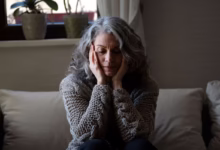 Mulher sentada com expressão triste, refletindo sobre os impactos da menopausa na saúde mental