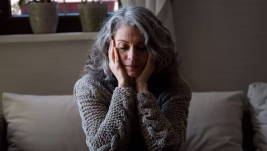 Mulher sentada com expressão triste, refletindo sobre os impactos da menopausa na saúde mental