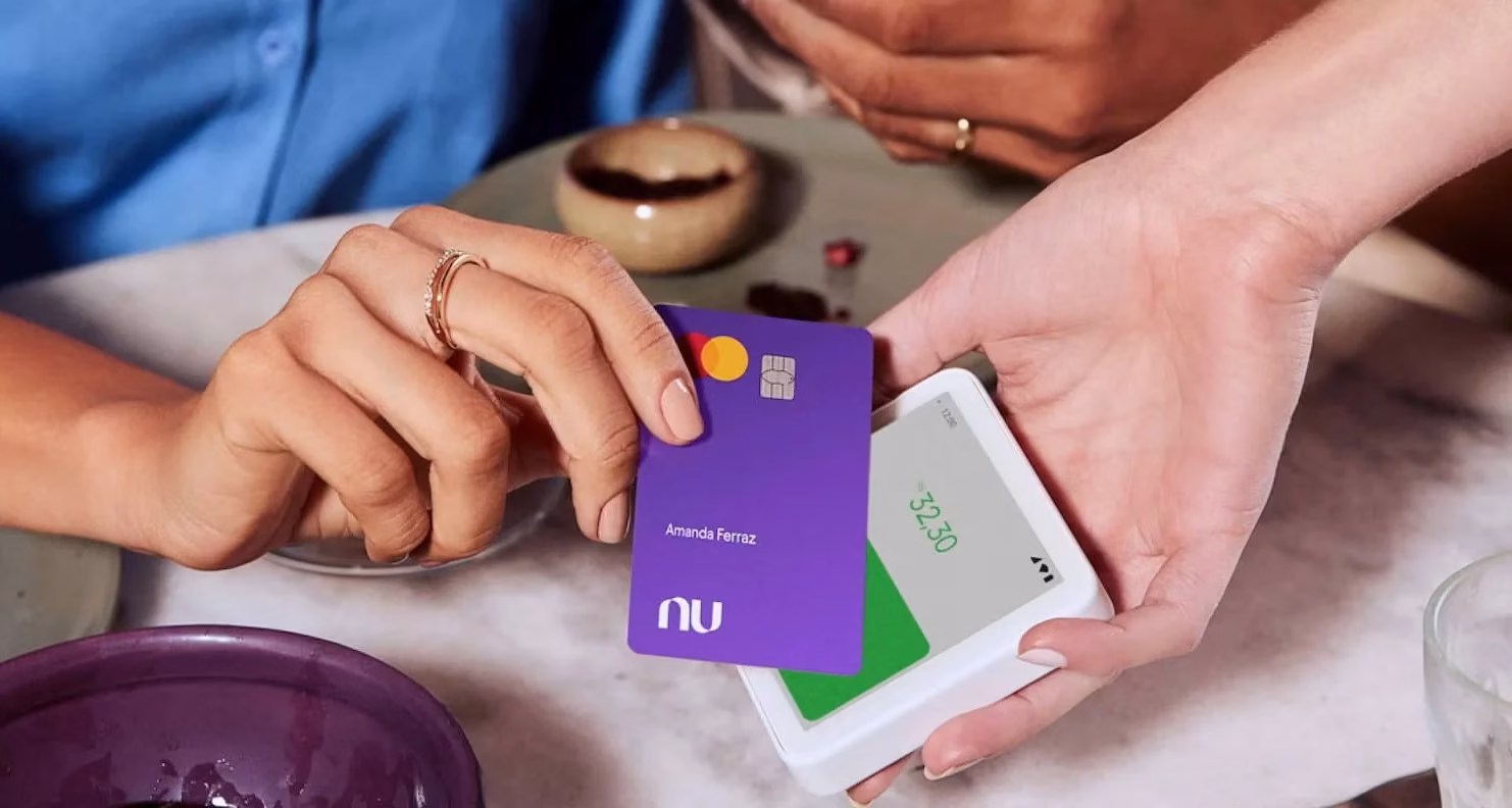 Cartão Nubank roxo sendo utilizado para pagamento em dispositivo de pagamento.