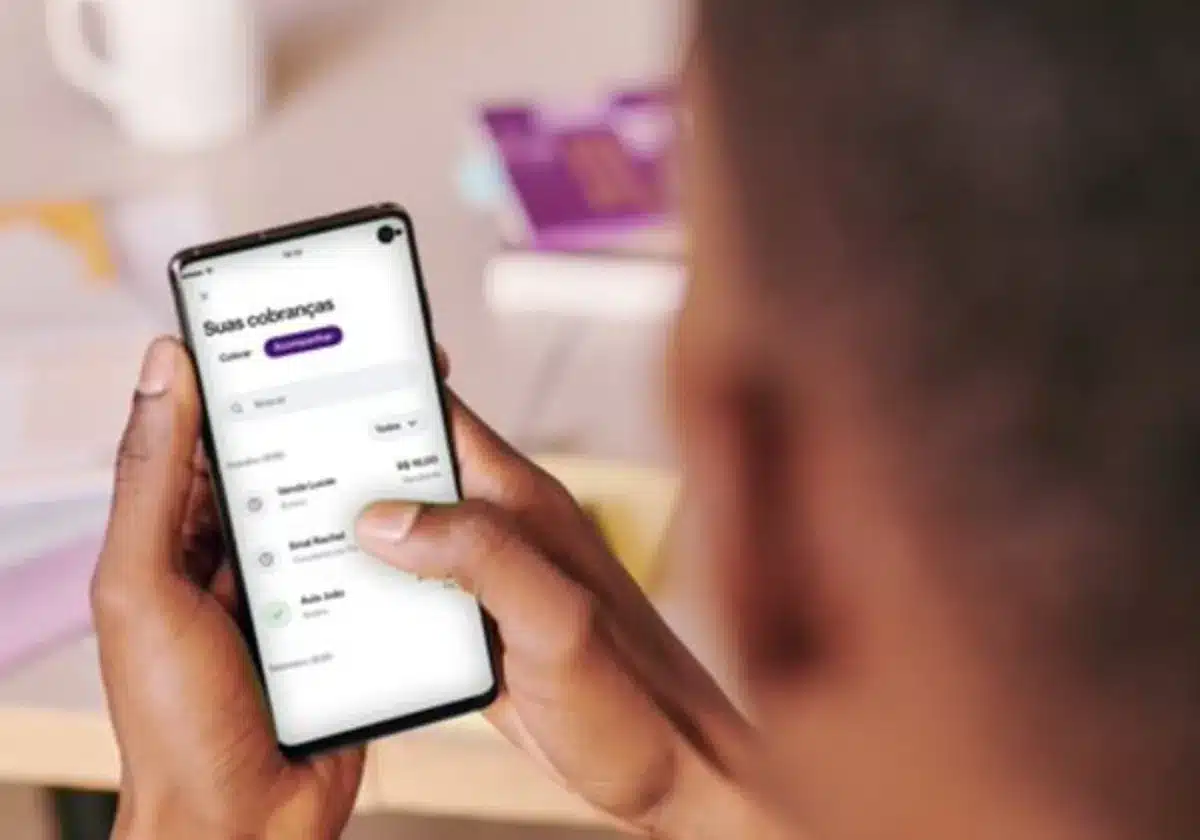 Cliente utilizando aplicativo do Nubank para acessar informações de cobranças em smartphone.