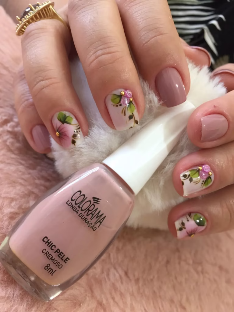 Unhas nude decoradas com flores delicadas, criando um design sofisticado e elegante.