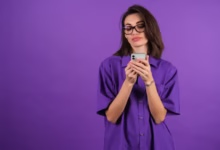 Mulher segurando celular, representando transferência de dinheiro do Nubank sem tarifas